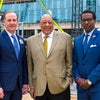 Mark Faulkner President and Chief Executive Officer Baptist Health Care with guests taking picture in front of topping off beam.