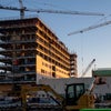 A shot of the building with two cranes