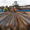 A photo shot down the side of rebar with men in the background