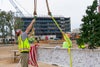 Workers attaching a flag to the beam