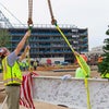Workers attaching a flag to the beam