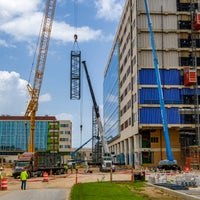 Crane lifting metal piece in front of new Baptist Hospital.