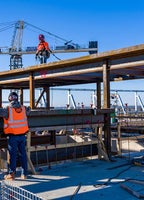 Workers standing on a beam