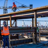 Workers standing on a beam