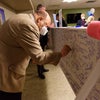 A man signing the beam with a blue sharpie