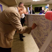 A man signing the beam with a blue sharpie
