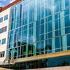 Front view of new campus building with wall of glass panels.