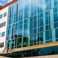 Front view of new campus building with wall of glass panels.