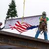 Workers holding the beam with the American flag flying