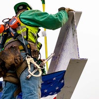 Worker steadying the beam
