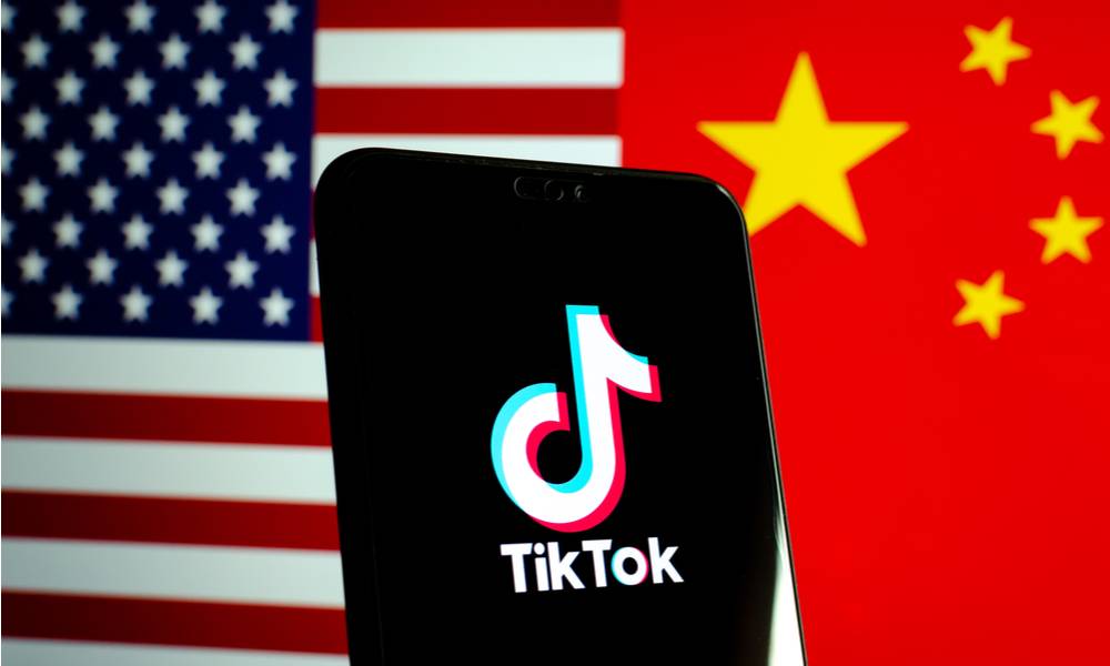 TikTok app logo on a smartphone screen and flags of China and US.jpg