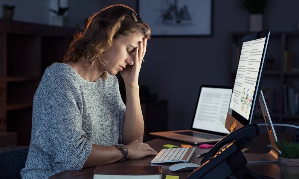 Woman working from home experiencing burnout symptoms.jpeg