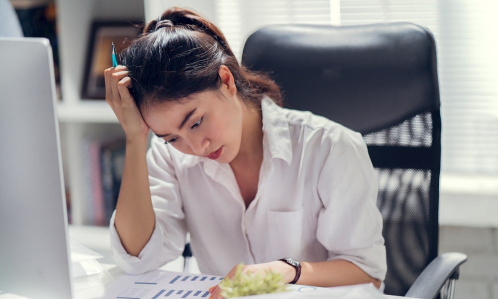 Business woman stressed at her desk mental health COVID-19-min.jpeg