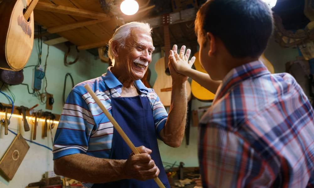 Grandson and grandfather high five each other family business.jpeg