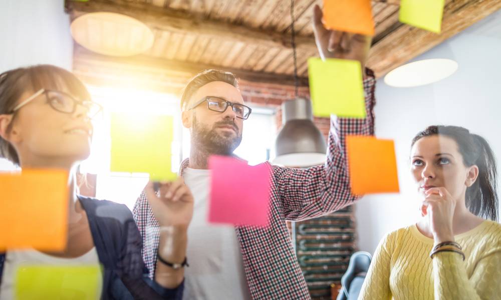 Business people meeting in an office using post it notes to share ideas.jpg