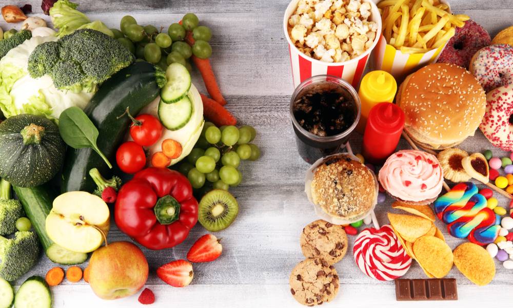 ealthy or unhealthy food. Concept photo of healthy and unhealthy food. Fruits and vegetables vs donuts,sweets and burgers on table.jpg