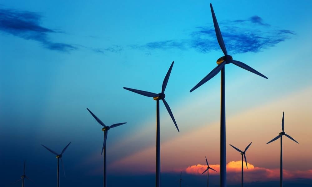 Wind turbine farm with rays of light at sunset.jpeg