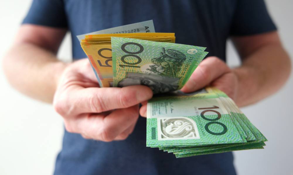 Man holding handful of bills counts money .jpg