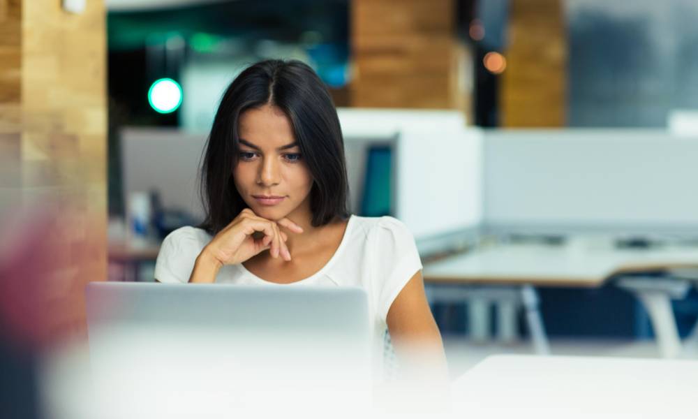 Portrait of a serious businesswoman using laptop in office.jpg