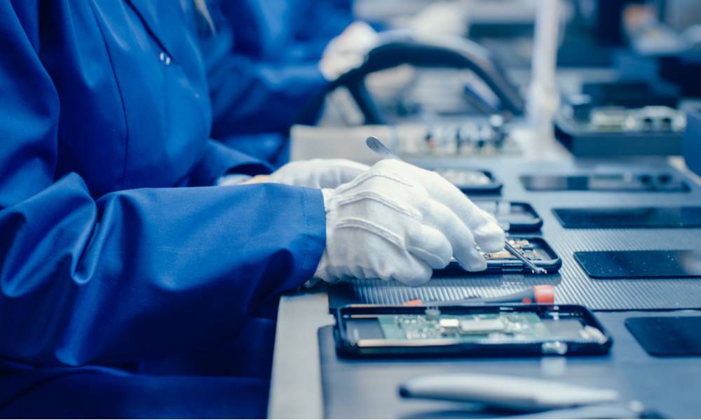 Factory worker assembling smartphones with screwdriver.jpg