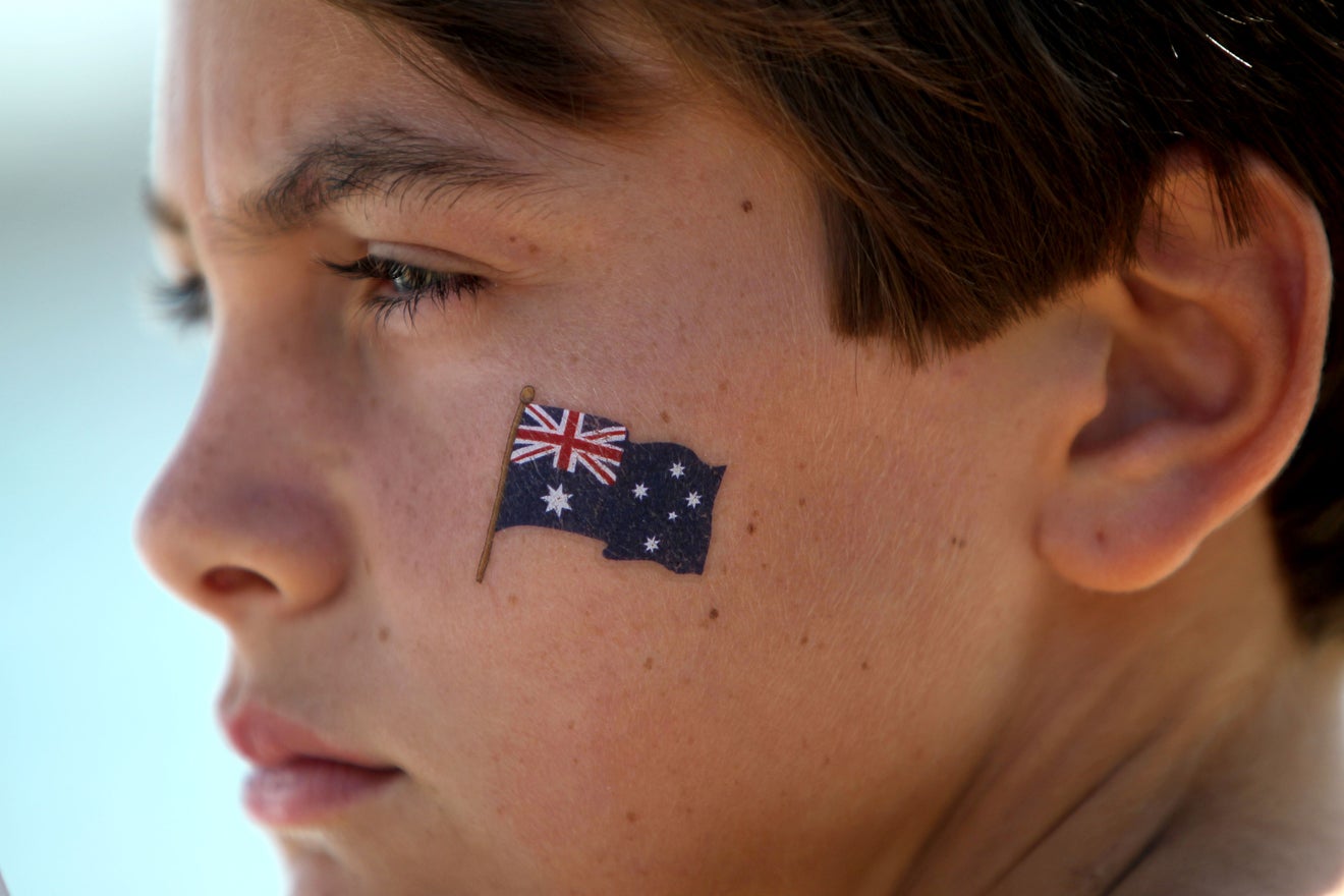 Profile of pensive boy with Australia flag tattoo on face