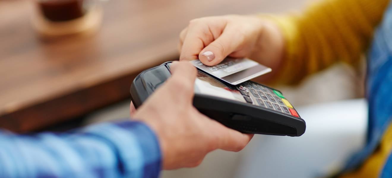 Hand holds credit card saving through spending for retirement 