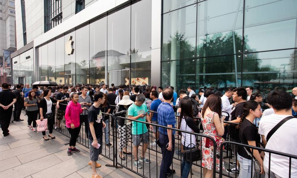 People queue outside Apple Store for the latest iPhone manufactured by cheap labour in their global supply chain.jpeg
