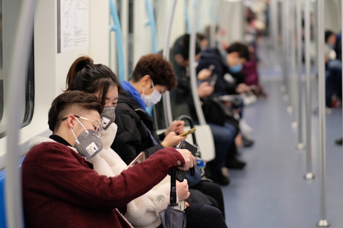 Coronavirus fears: a family wearing surgical mask waiting at bus station in Shanghai