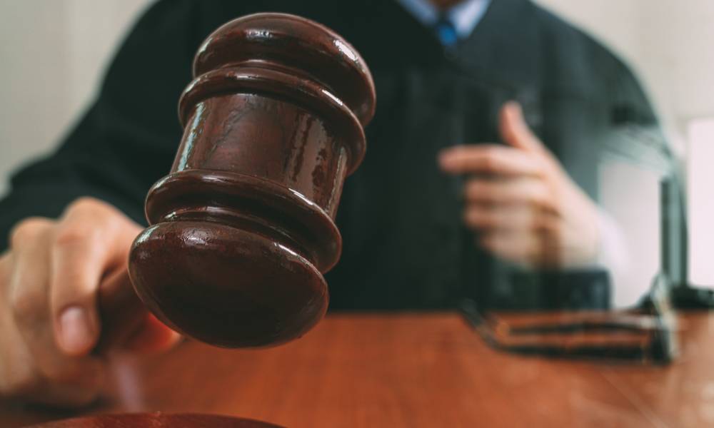 Judge in a courtroom with the gavel,working with smart phone,digital tablet computer docking keyboard,eyeglasses,on wood table (1).jpg