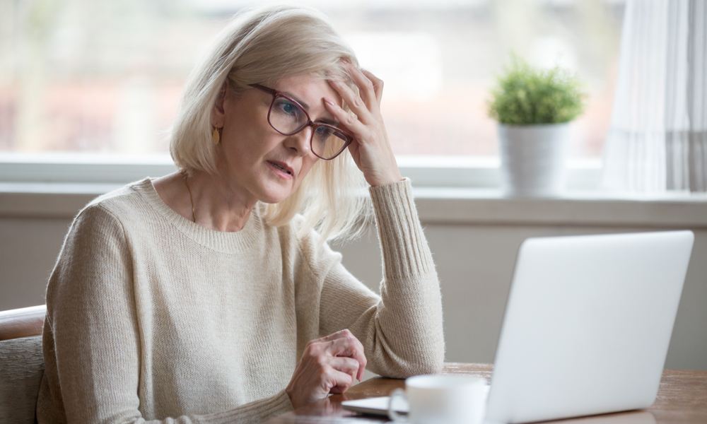 Thoughtful confused mature business woman receives emails from organisational leader about a crisis.jpeg