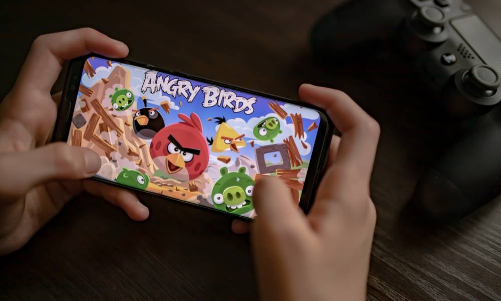 Hands hold a smartphone with Rovio's Angry Birds game on the screen.jpeg