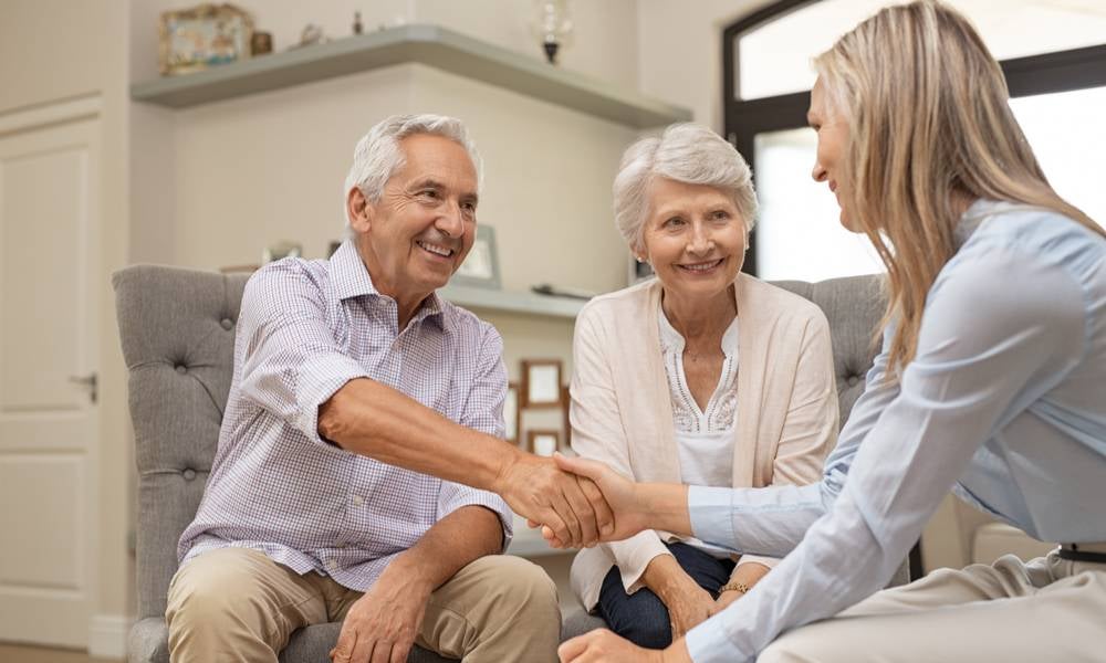 Older couple shake hands with financial adviser sustainable aged care financing model.jpeg