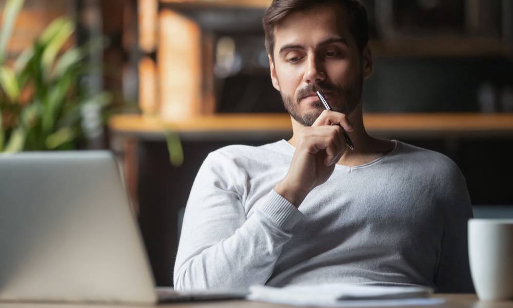 Pensive bearded man sitting at table drink coffee work at laptop thinking of problem solution (1).jpg