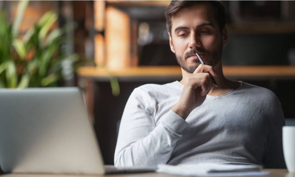 A man thinking while working on a laptop from home (1).jpg