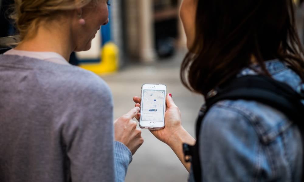 Two women ordering a taxi via an app.jpeg