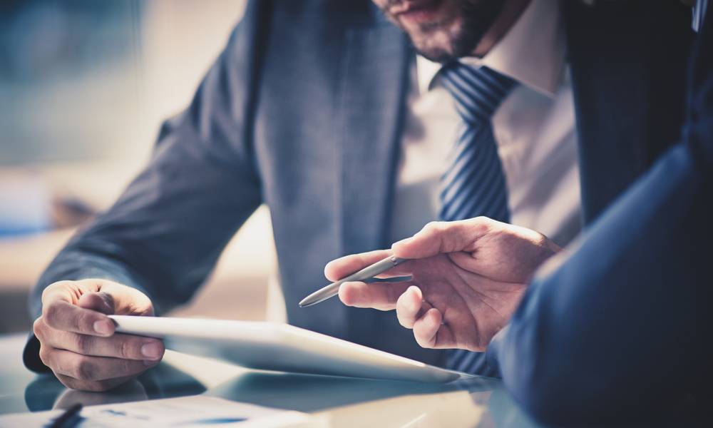 Close-up of two businessmen looking at a chart on a digital tablet.jpg