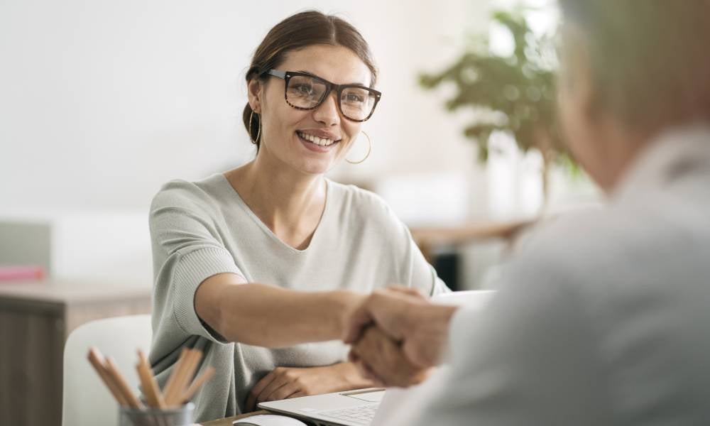 Job candidate shakes hands in an interview showing controlled enthusiasm.jpeg