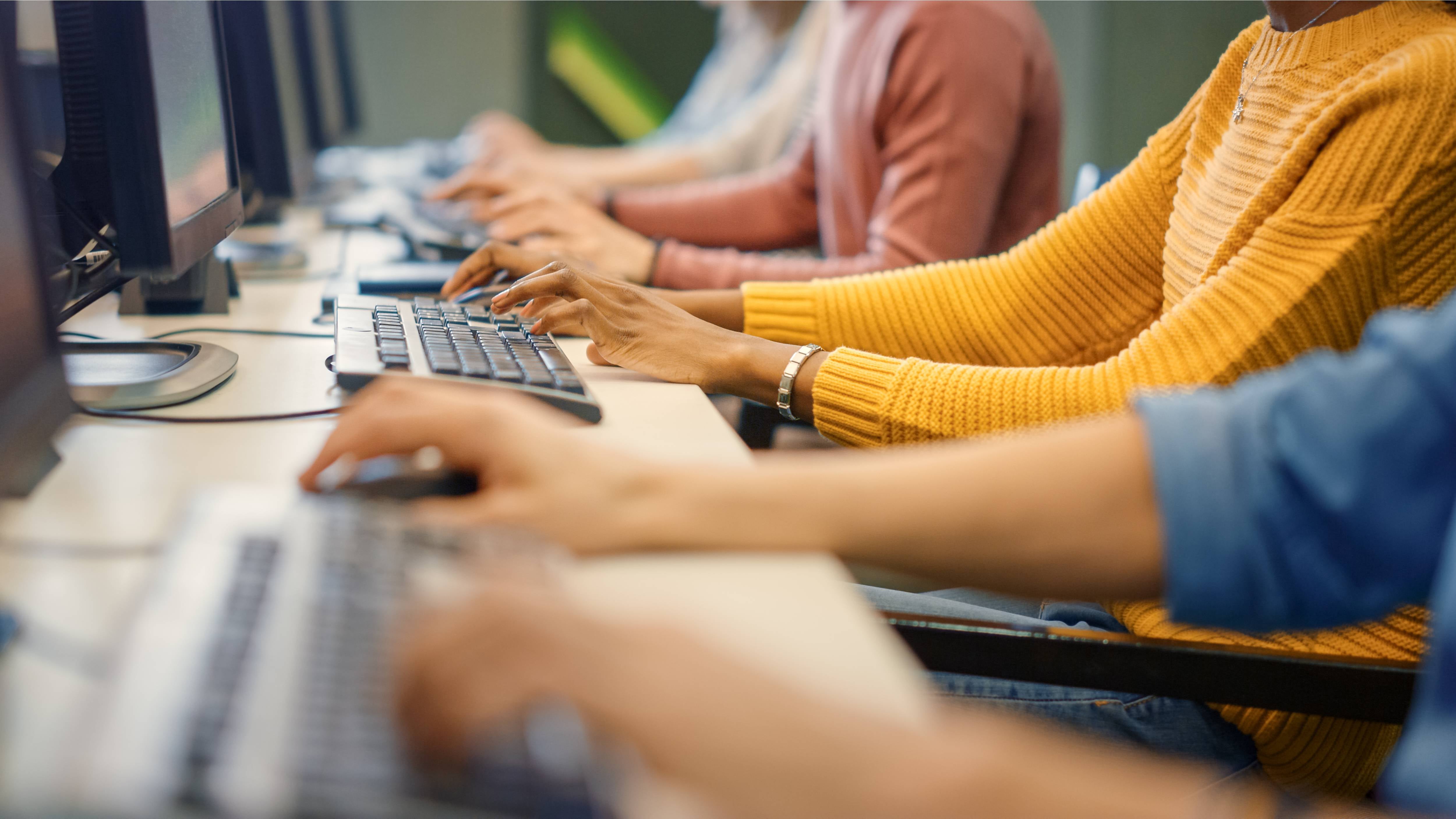 Row of diverse group of multi-ethnic people works on a computer.jpeg