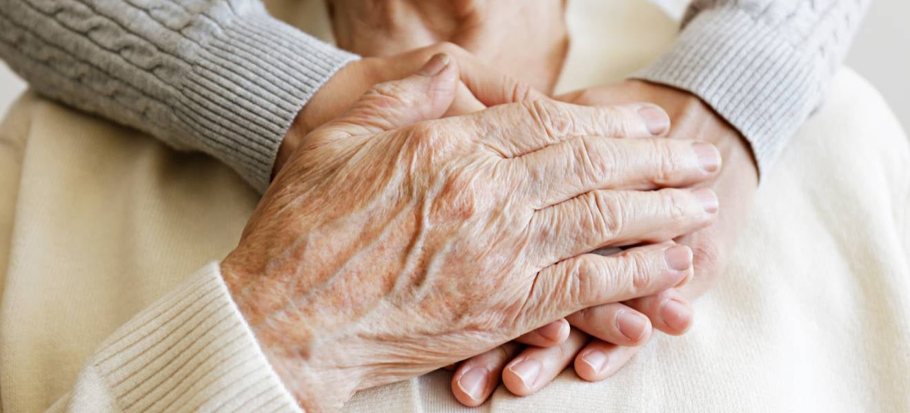Grandmother holding daughter's hands over heart sustainable aged care funding