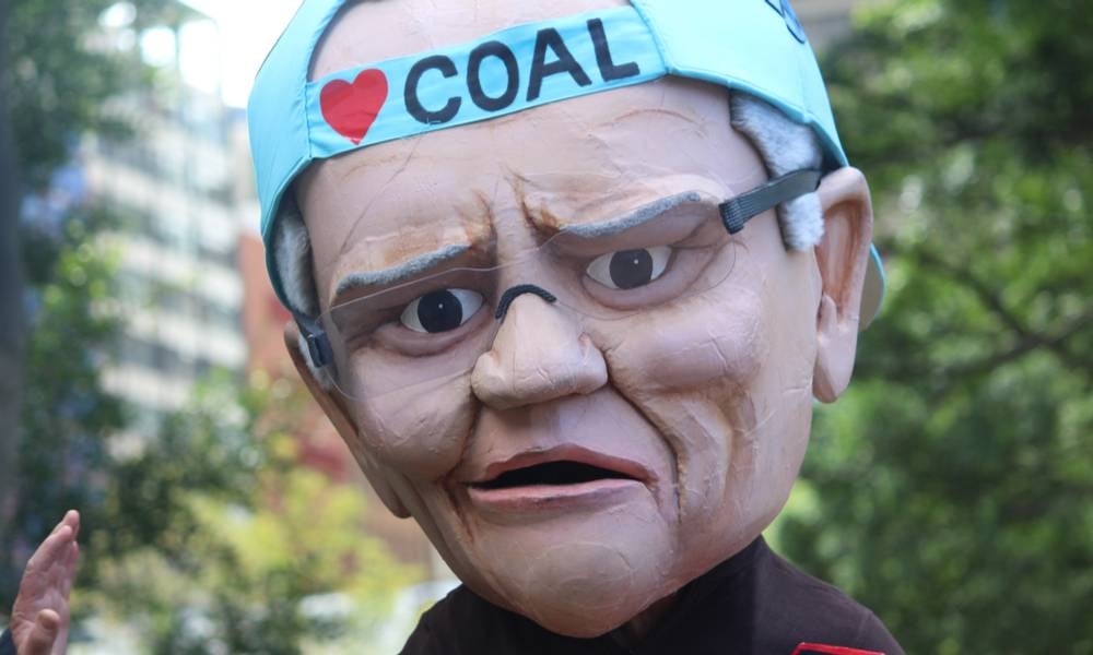 The climate change strike. Pictured is a man wearing a huge caricature mask of prime minister scott morrison wearing a blue baseball cap.jpg