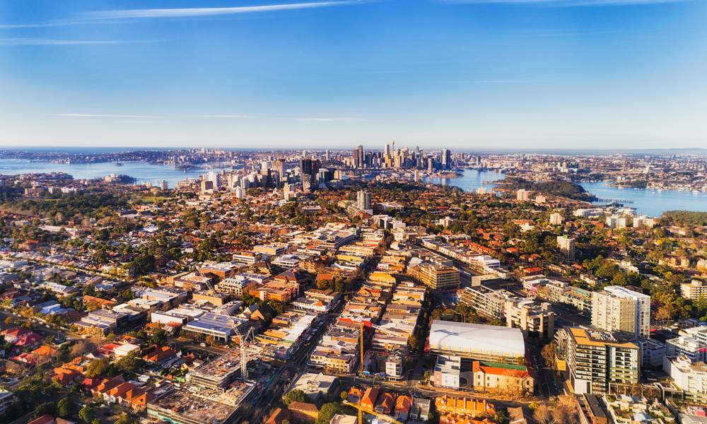 Local residential suburbs in Inner city of Sydney on shores of Sydney harbour viewed from above mid-air on a sunny day facing CBD landmarks.jpg