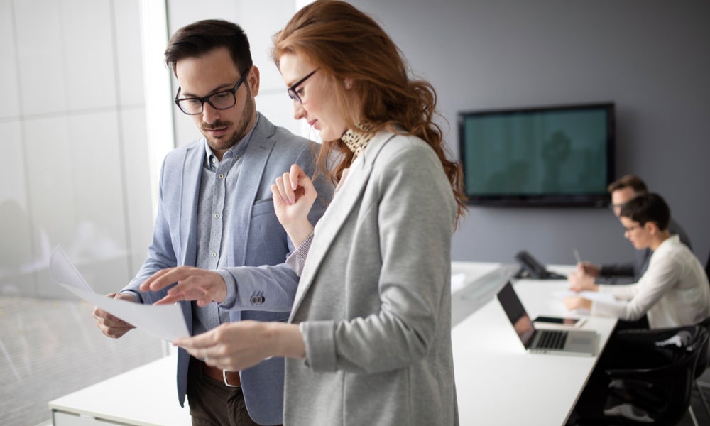 Two colleagues discussing a document.jpeg