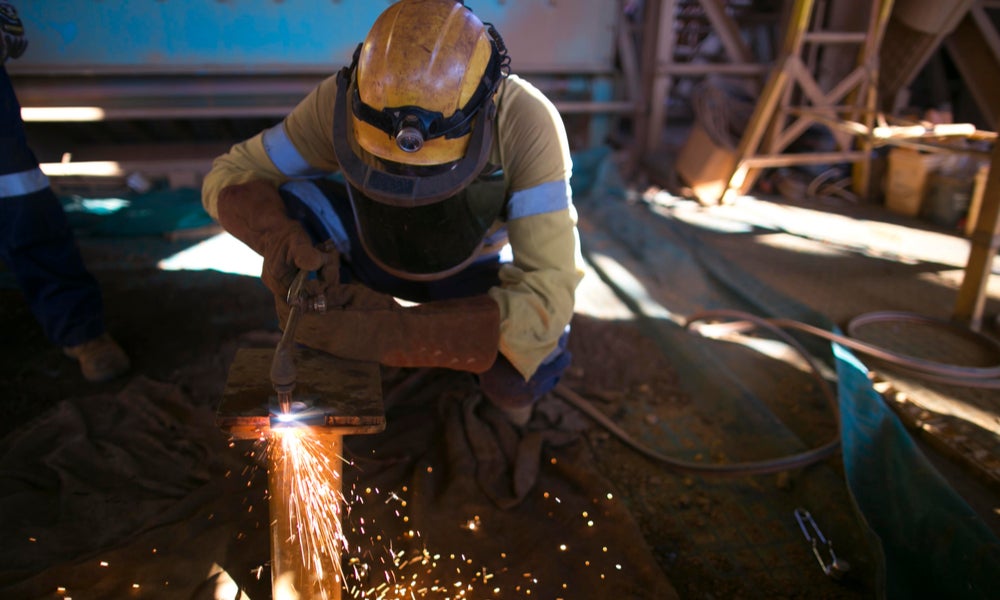 Construction worker cutting steel plate at mining site-min.jpg