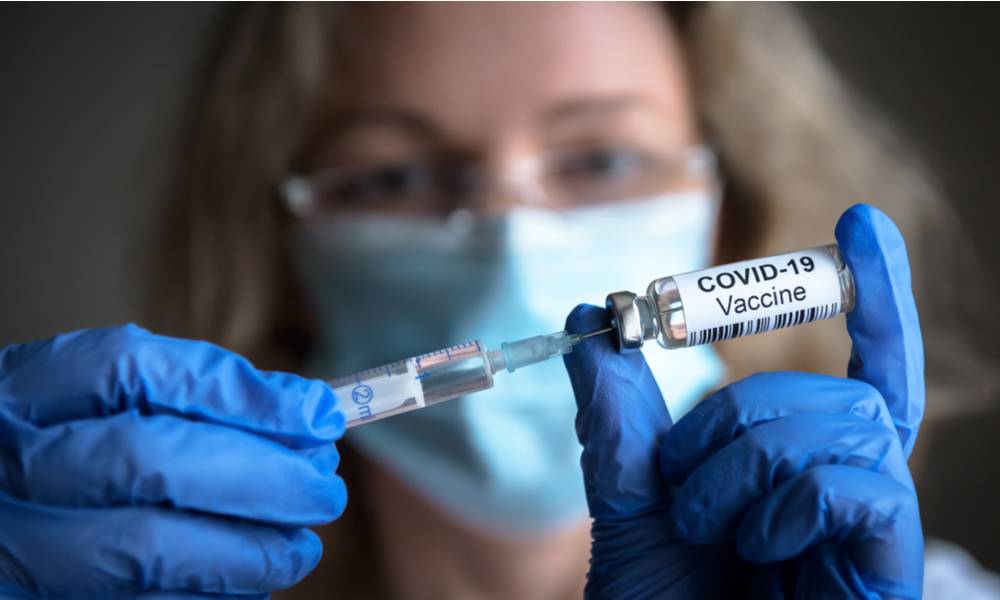 Health worker hold COVID-19 vaccine and syringe in hand (1).jpg