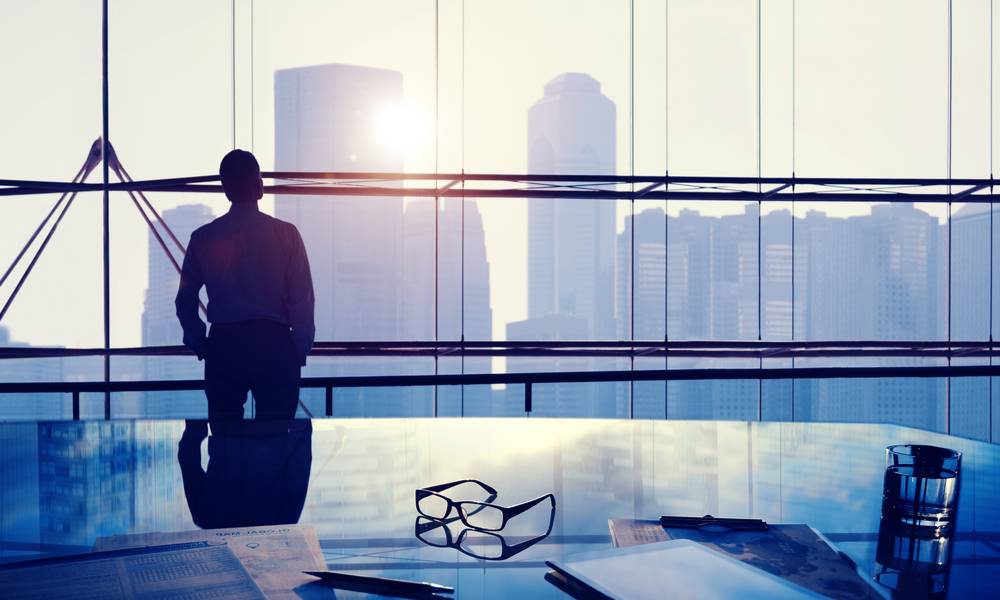 Businessman thinking inside coirporate office with view of city skyline (1).jpg