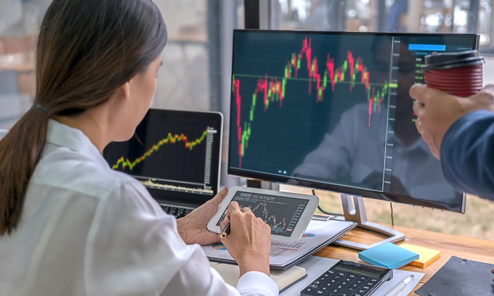 Investor on computer and tablet trading stocks-min.jpg