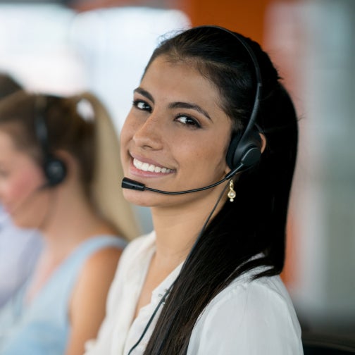 Call center worker smiles at the camera.