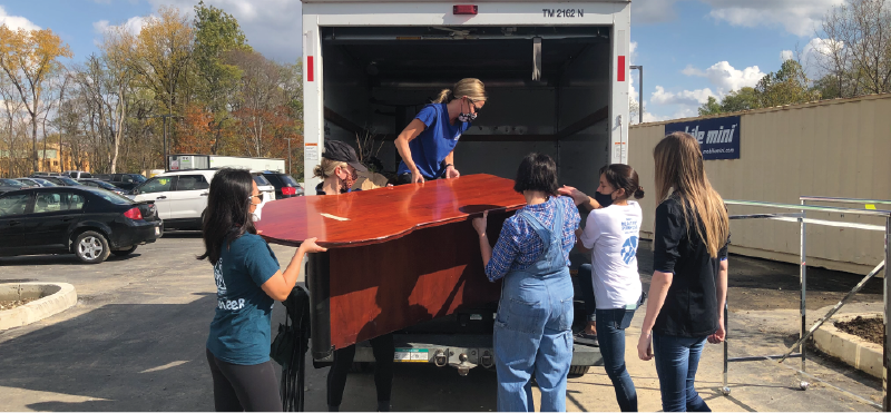 Elanco employees lifting furniture into a truck