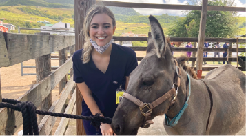 Photo of intern Mariya Axenoff and a donkey