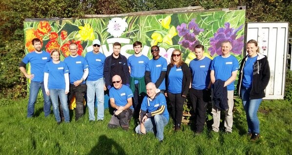 a group of employees standing together in front of a mural